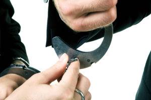 A Woman releasing a man chained to her in handcuffs (close-up)